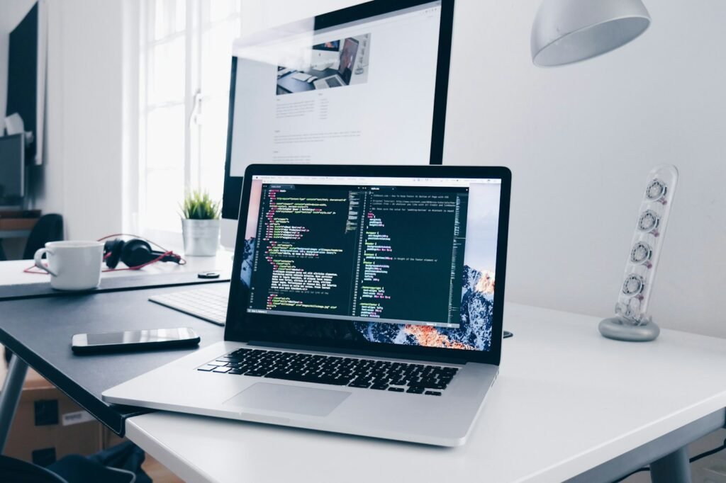 Agence web Paris : poste de travail avec ordinateur portable et code pour la création de site