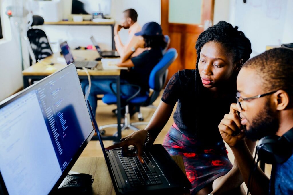 Contact : deux collègues échangent devant un ordinateur sur un projet web